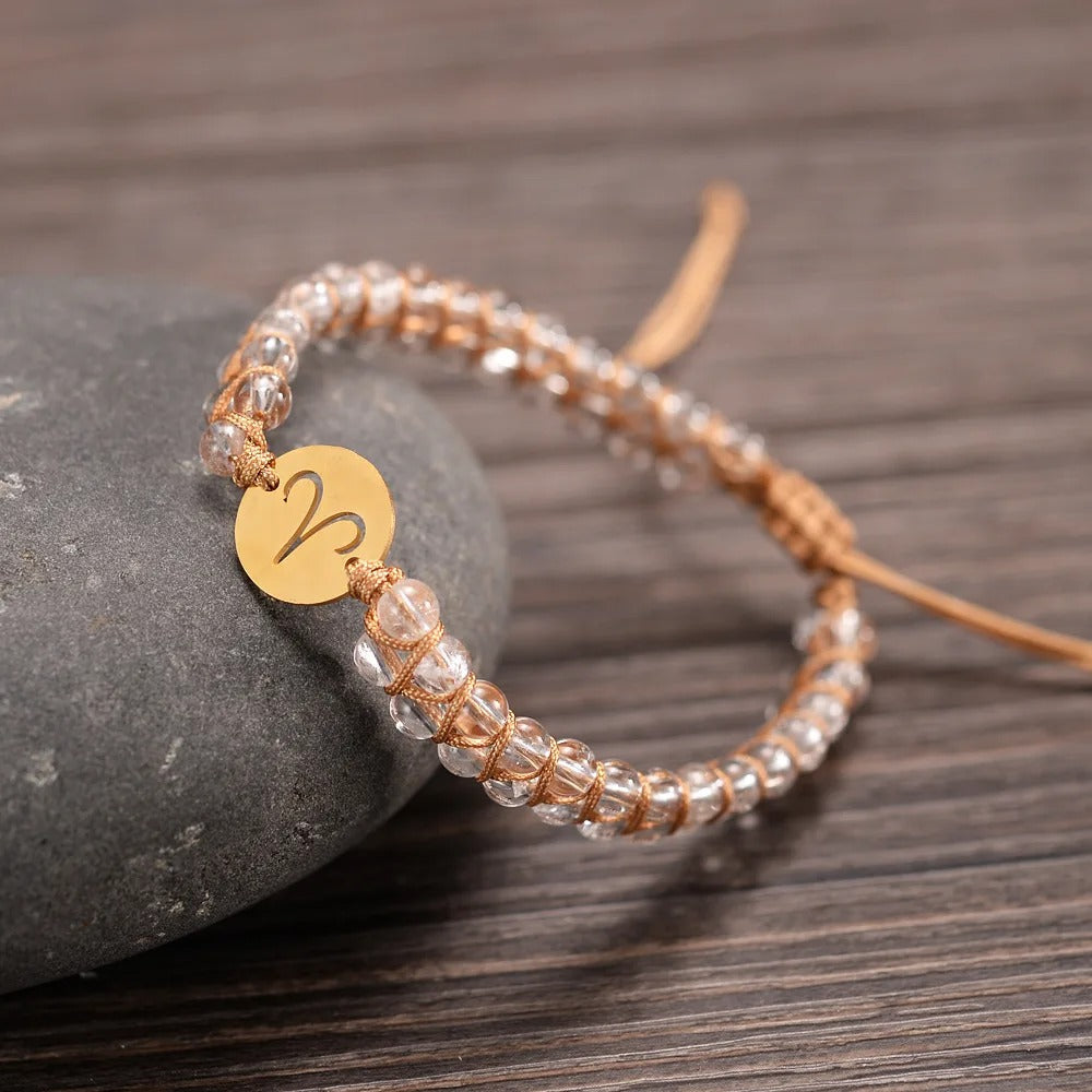Zodiac bracelet; Braided design; Handcrafted zodiac jewelry; Unique astrological accessory; Artisan-crafted bracelet; Ethically sourced materials; Gift for astrology enthusiasts; Stylish and comfortable for daily wear; Beautiful braided details; Personalized zodiac sign representation; Perfect for layering with other bracelets; Unique spiritual gift; Bracelet for intention setting; Durable and fashionable design; Ideal for any occasion; Symbol of celestial connection;