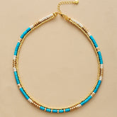 Gold-plated choker necklace; Turquoise and seed accents; Elegant and stylish accessory; Perfect for layering with other necklaces; Unique blend of color and texture; Eye-catching design for any occasion; Ideal gift for fashion enthusiasts; Handcrafted with high-quality materials; Lightweight and comfortable to wear; Durable gold plating for long-lasting shine; Bohemian-inspired jewelry piece; Enhances any outfit with a pop of color; Ethically sourced materials;