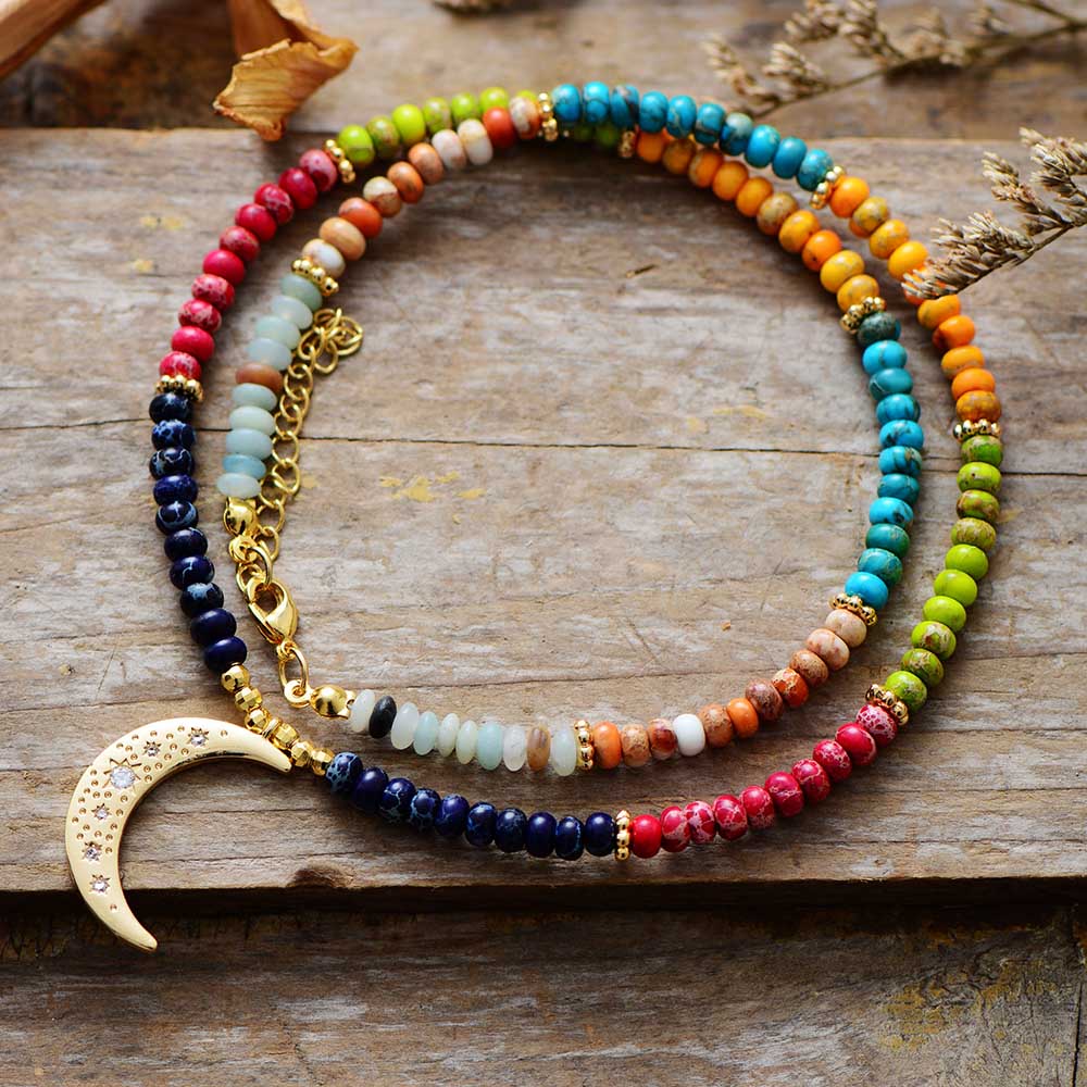 Chakra colors moon necklace; Natural stone necklace with imperial jasper; Enhances chakra alignment and balance; Beautifully designed moon pendant; Supports emotional healing and well-being; Unique blend of colors for each chakra; Ideal gift for spiritual and wellness enthusiasts; Handcrafted with care and attention; Lightweight and comfortable for everyday wear; Perfect for layering with other necklaces;