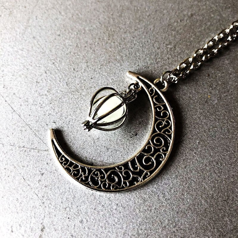 Luminous moon pendant necklace; Glows in the dark jewelry; Moon-inspired glowing necklace; Unique celestial necklace design; Captures the magic of the night sky; Perfect gift for moon lovers; Ethereal glow in the dark pendant; Handcrafted luminous jewelry; Stylish accessory for day or night; Symbol of mystery and elegance; Adds a touch of celestial beauty;