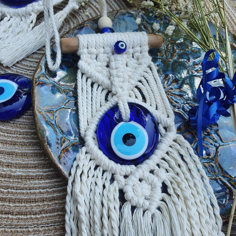 Greek eye amulet; Macramé protection amulet; Evil eye home decor; Protection for home and spaces; Handcrafted Greek eye amulet; Spiritual macramé wall hanging; Greek eye for warding off negativity; Unique protection decor; Evil eye macramé art; Home protection amulet; Greek eye for energy shielding; Boho-style Greek eye amulet; Holistic protection decoration; Amulet for peace and protection; Gift for home blessings; Evil eye symbol for protection;